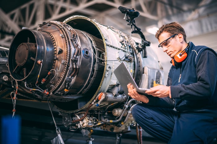 A mechanic working on a jet engine.