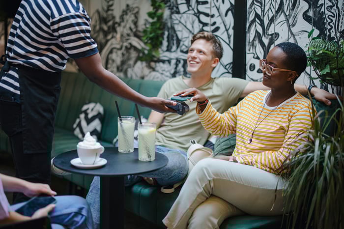 Person making a payment with a smartphone in a restaurant.