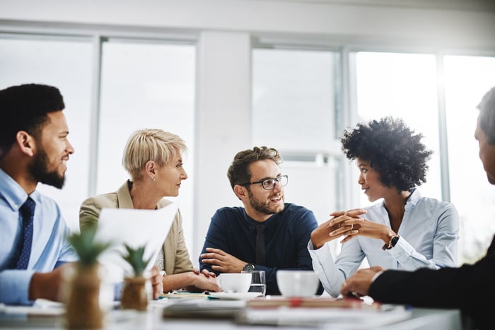 A group of people discuss something in a conference room.