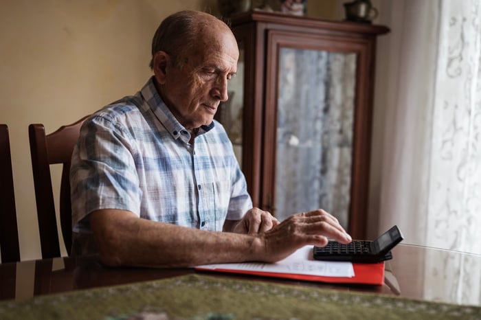 A person at a table using a calculator.