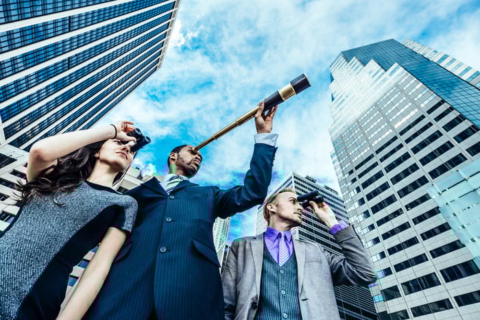 Three business people peering off into the distance.