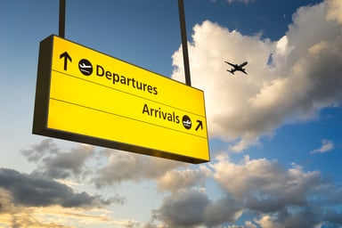 24_11_14 A yellow sign that says arrivals and departures on it with an airplane in the background _MF Dload GettyImages-491941069-1200x800-5b2df79