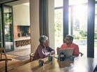 Two people at a table with a laptop open_GettyImages-1141194414