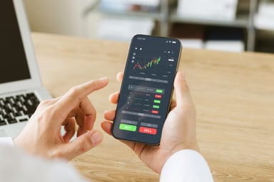 23_11_06 A person looking at a stock trading phone app _MF Dload GettyImages-1436743497