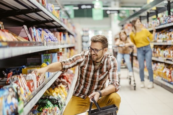 Shopper taking an item off a store shelf.