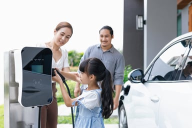 A family recharges an electric vehicle in a garage. (1)