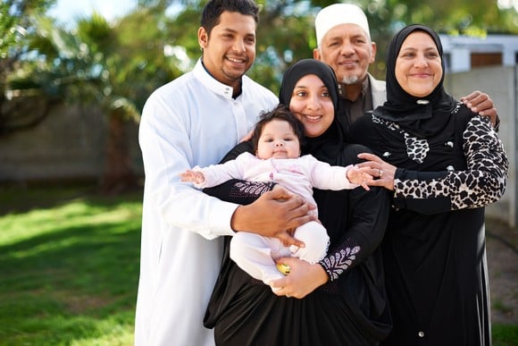 An extended family of five, including a baby, posing for a photo.
