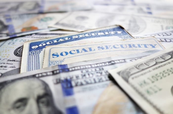 Two Social Security cards intermixed with U.S. currency.