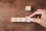 Person turning a cube from 2024 to 2025