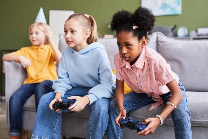 Group of three young people seated on a couch.