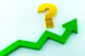Gold question mark over a rising green stock market arrow laid out on graph paper.