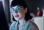 investor-looking-at-charts-on-a-computer-with-light-reflecting-off-their-glasses