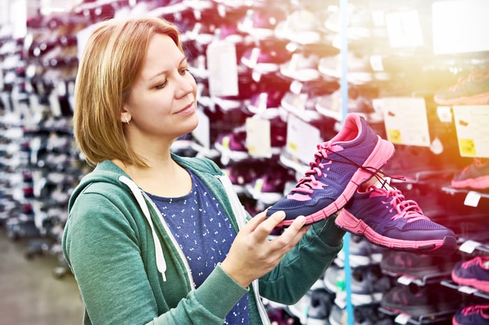 A person shopping for sneakers in a store.