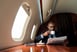 Person reading a newspaper on a private jet.