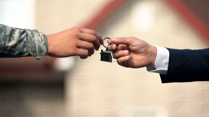 A U.S. soldier and businessperson exchanging a keychain.