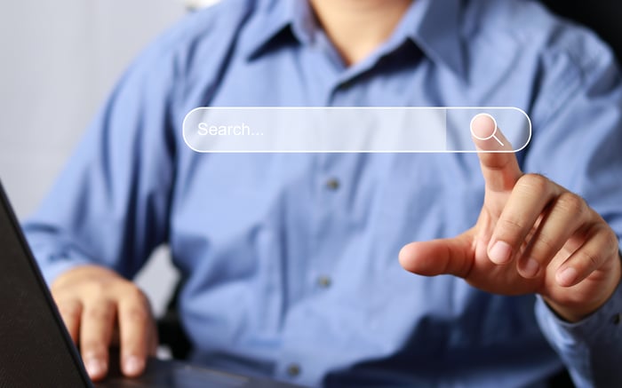 A person clicking an online search bar.