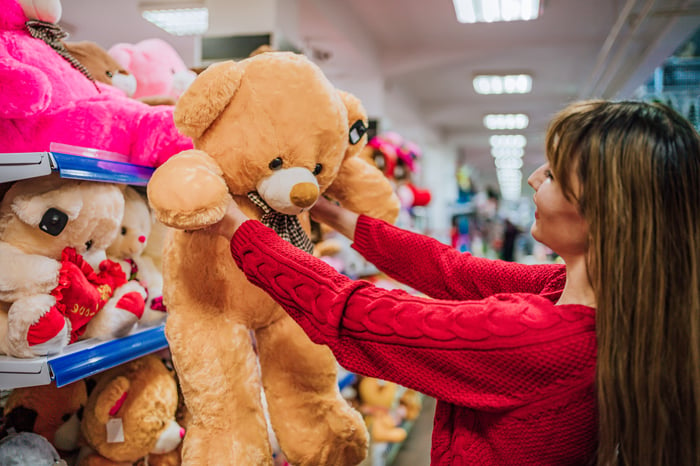 A person holding up a teddy bear. 