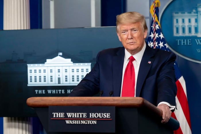 Donald Trump standing at a White House podium.
