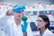 Chemist team looking beaker of green chemical