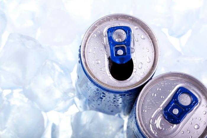 Tops of two beverage cans in ice. 