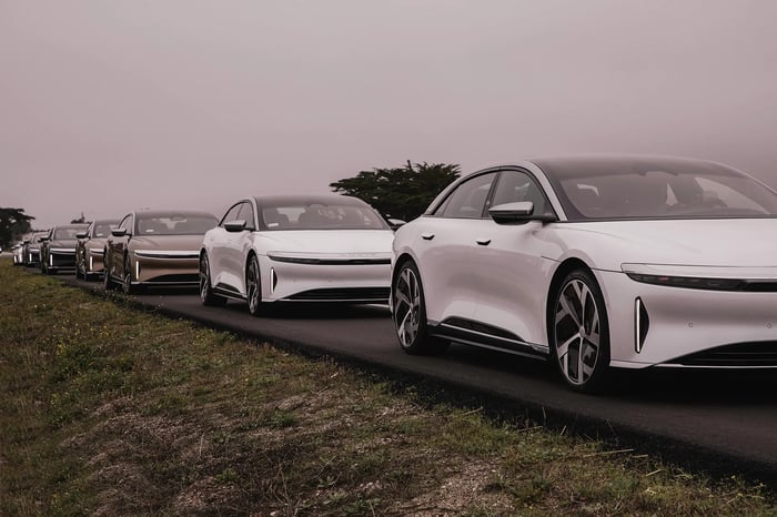 Image shows rows of Lucid Air vehicles on the road.