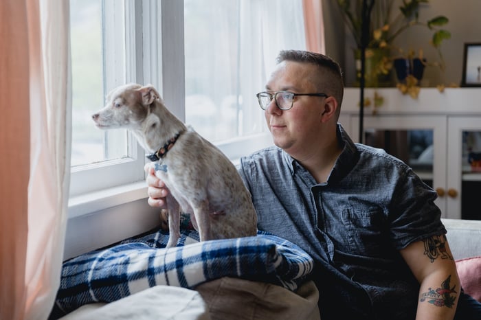 Someone is looking out a window with a dog.