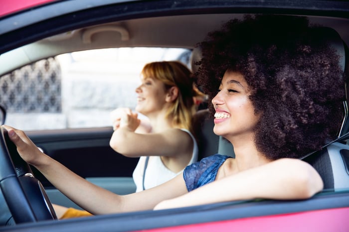 Two people enjoying music in a car.