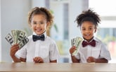 2 kids holding American currency