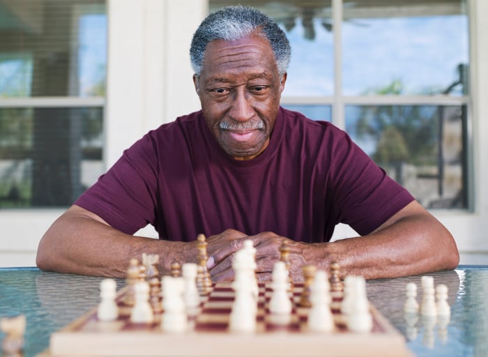 Person studying chessboard.