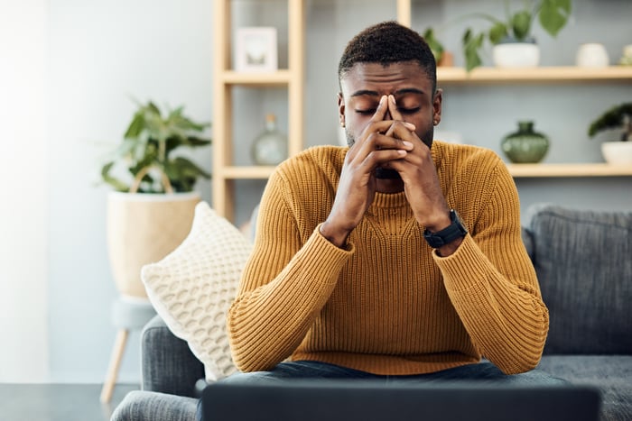 Person with a worried expression sitting on a couch.