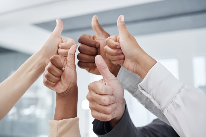 Five hands are shown, each with a thumbs-up gesture.