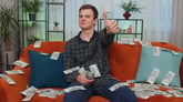Man on couch with money 2024