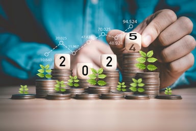 2025 displayed on wooden blocks sitting on coin stacks