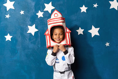 child in a spacesuit with handcrafted rocket on head.-1200x800-5b2df79
