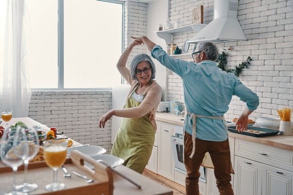 Older couple dancing in a kitchen.