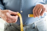 Person measuring their waist.