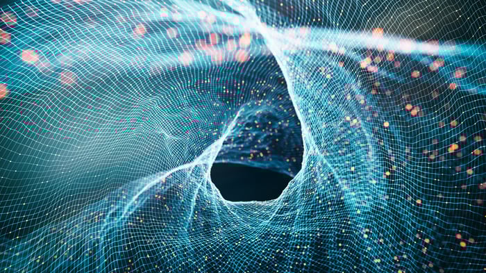 A swirling, colorful, abstract image representing the wave-particle duality of quantum mechanics.
