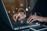 A person searching for ETFs on a laptop.