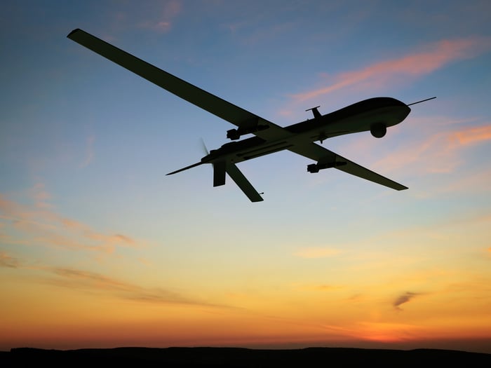 Military drone flying at dusk.