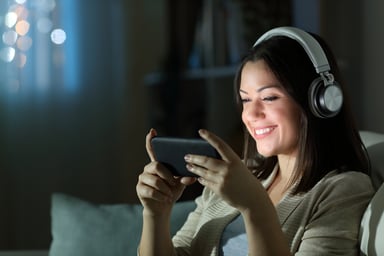 smiling-at-a-smartphone-while-listening-to-music-on-headphones