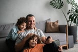 A father and two boys watching a screen