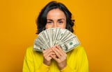 Person holding many hundred dollar bills.
