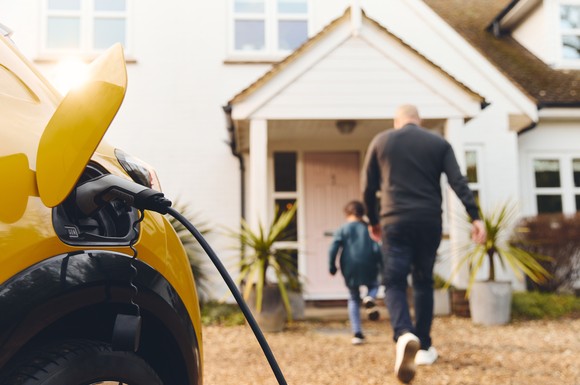 An EV charging in front of a house.