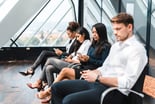 people in suits looking at their phones