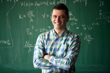 Getty - smiling happy teacher in front of blackboard