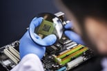 technician examines semiconductor with magnifying glass getty (1)