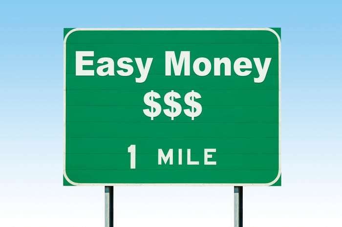 A road sign that says easy money 1 mile.
