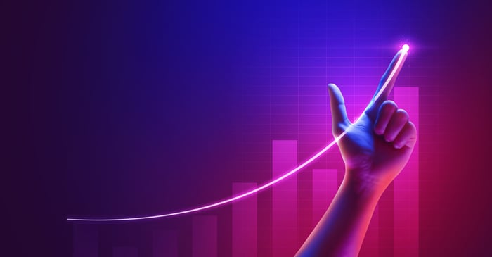 Finger gun pointing up on a neon pink stock market chart background.