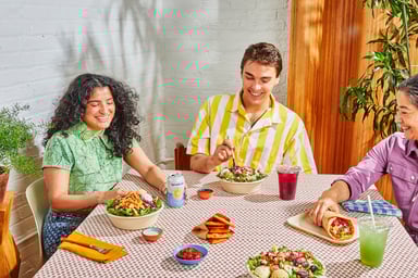 Cava lifestyle picture showing three diners at a restaurant