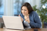 Woman with fingers crossed laptop